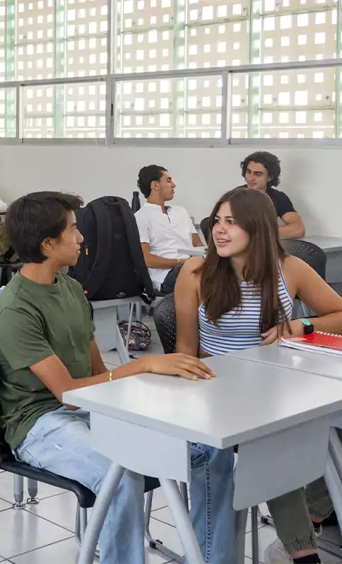 Alumnos hablando en salón.