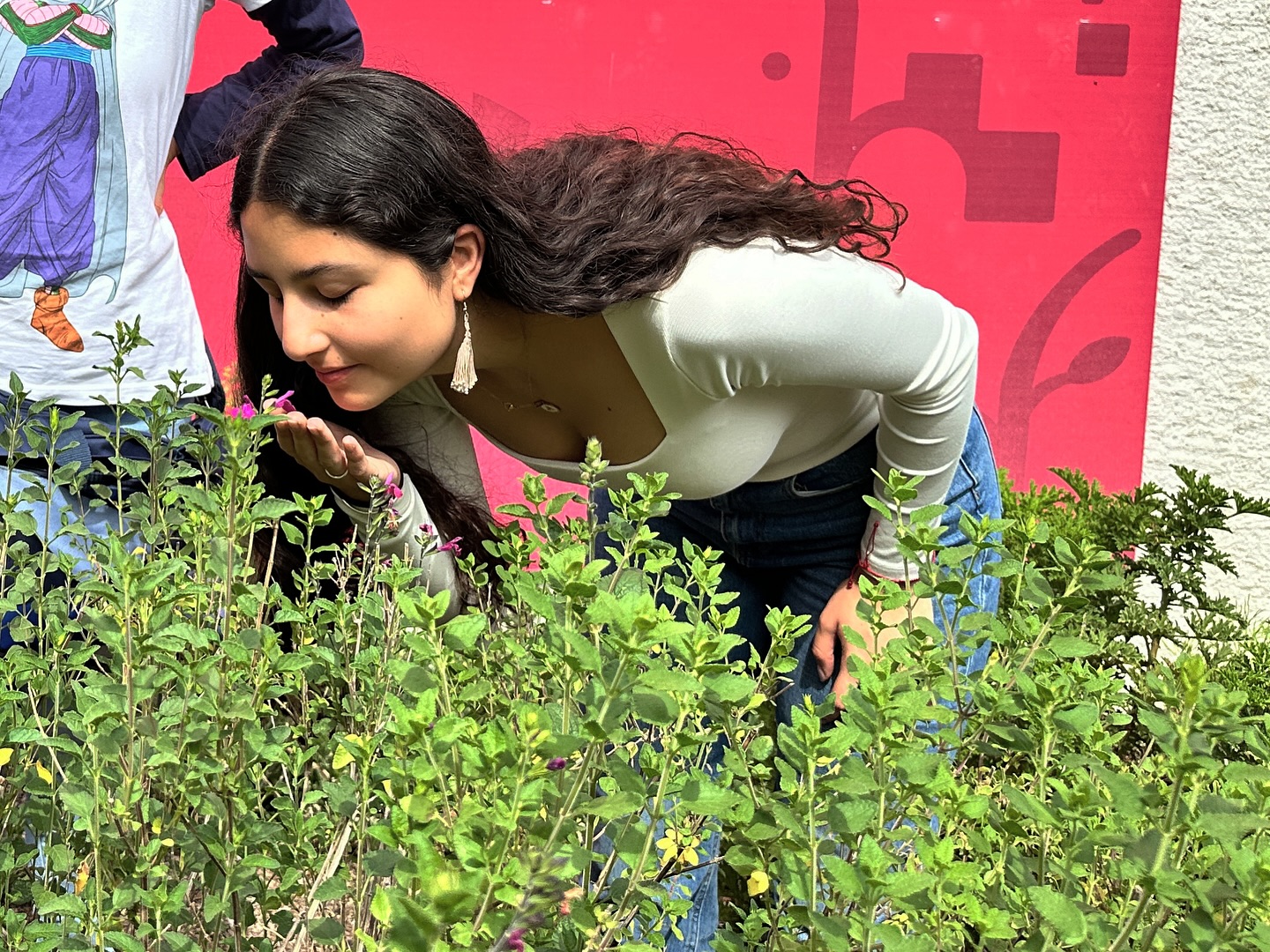 Alumna oliendo flores